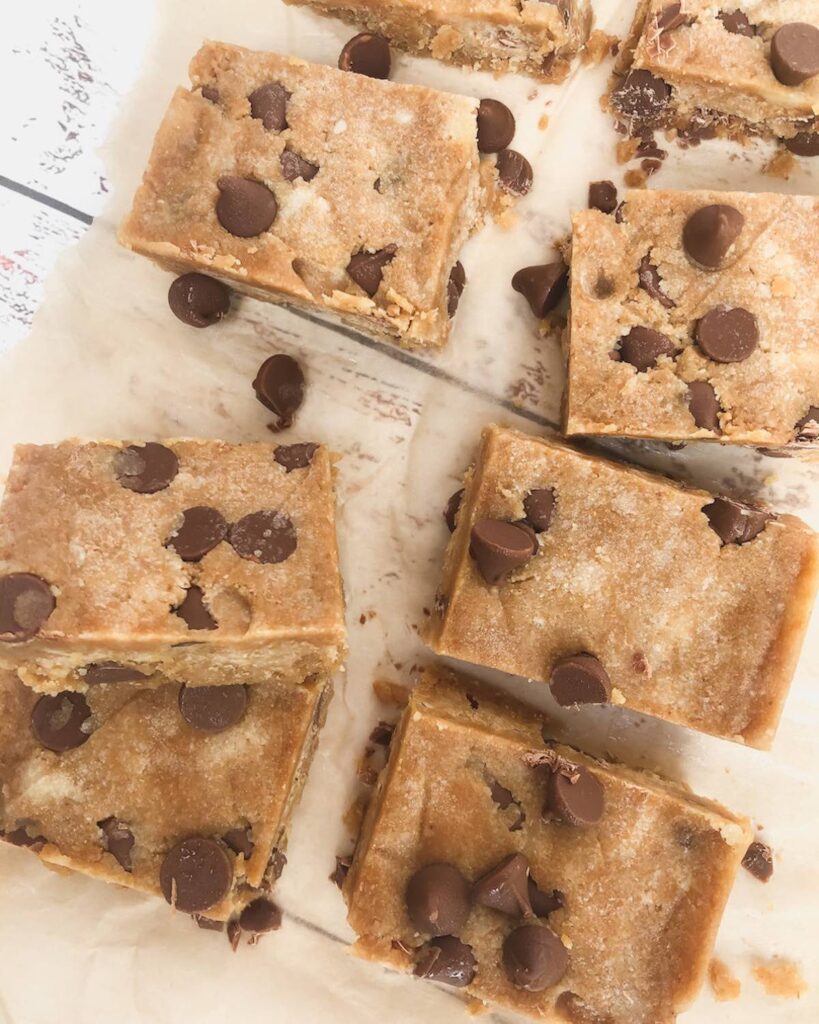 Squares of cookie dough protein fudge on baking paper