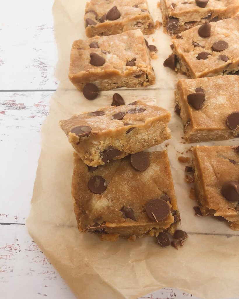 Squares of cookie dough protein fudge on baking paper